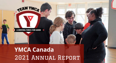 Team YMCA, a driving force for good shield logo on top of a image of a group of young YMCA staff and children putting their hands together in a circle to do a group cheer. YMCA Canada 2021 annual report.
