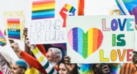 People holding up signs that say Love is Love and Fighting for Equality