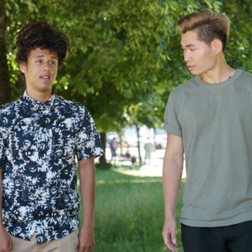 Two people walking outside talking to each other